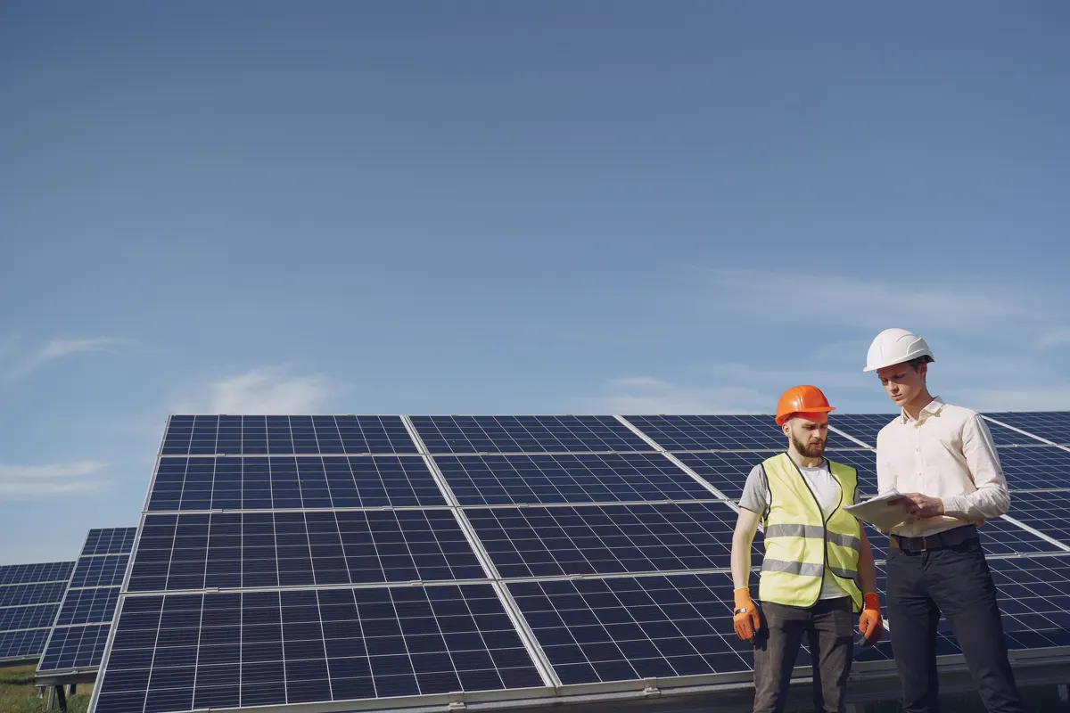 Zwei Techniker prüfen eine Photovoltaikanlage